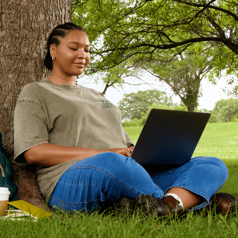 Complete I-9 form online with notary - Woman using laptop under tree for remote I-9 verification session